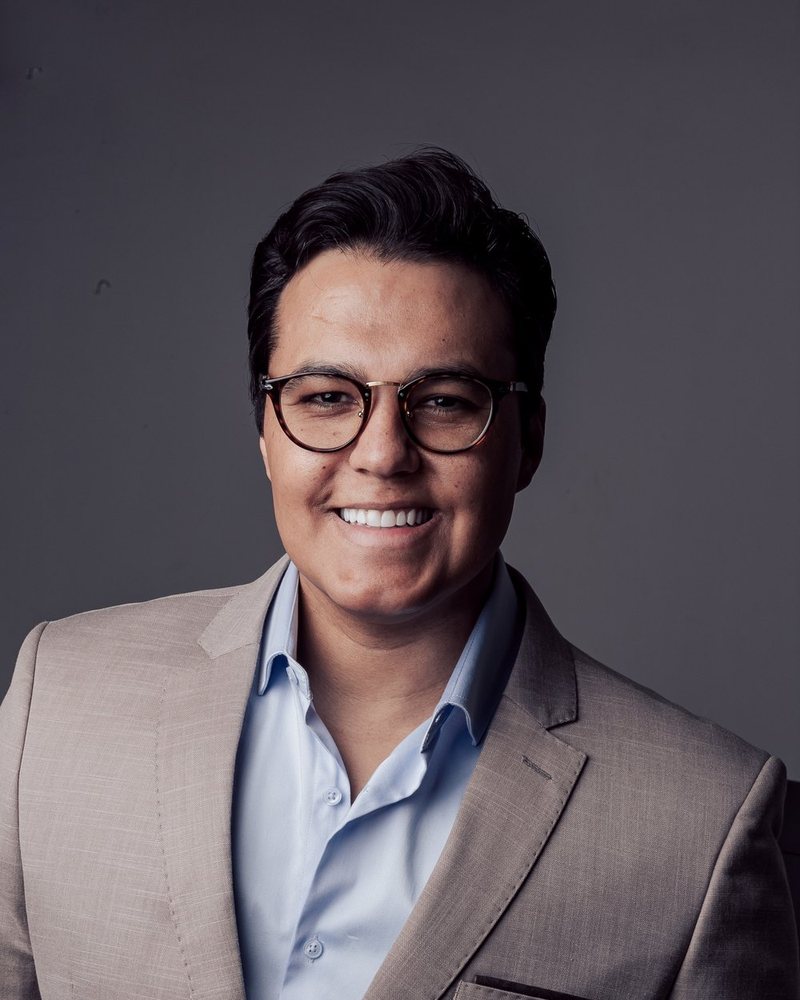Cassiano Oliveira, fundador do SisHub, de terno claro sobre fundo cinza